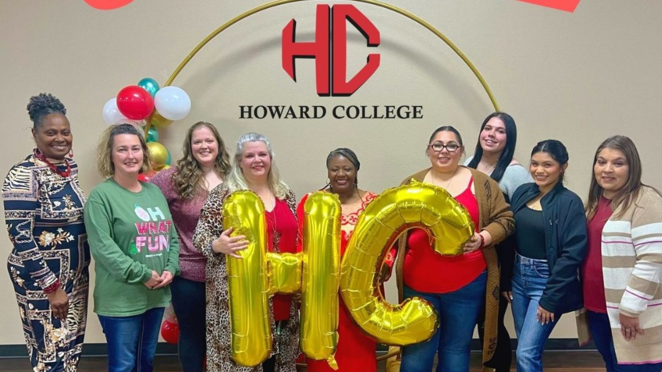 Cottage staff members pose for a group photo with gold balloon "HC" letters