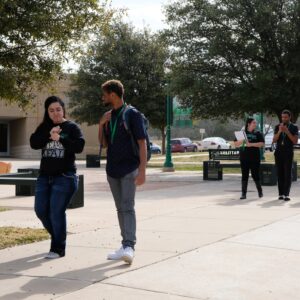 Students signing while walking on campus