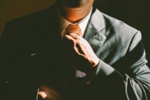 Image of man in business suit adjusting neck tie