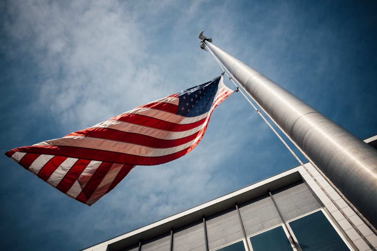 Closeup of flag pole with American flag waving in wind